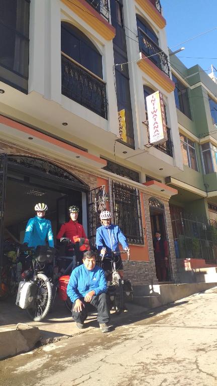 een groep mensen op motorfietsen geparkeerd buiten een gebouw bij Hostal Intiwatana Inn in Puno