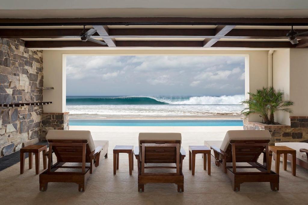 un patio con sillas y vistas al océano en Fort Walker (Beachfront House), en Rivas
