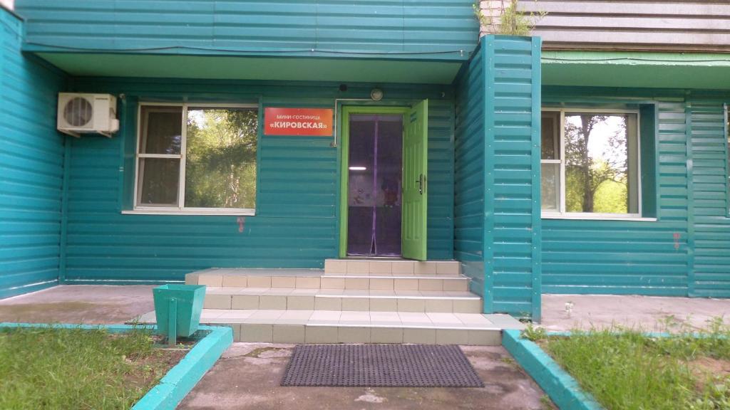 ハバロフスクにあるMini Hotel on Kirovaの青い家 緑のドアと階段