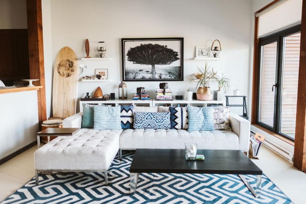 uma sala de estar com um sofá branco e um tapete em Pacific Soul Eco-Luxe Vacation Home em Ucluelet