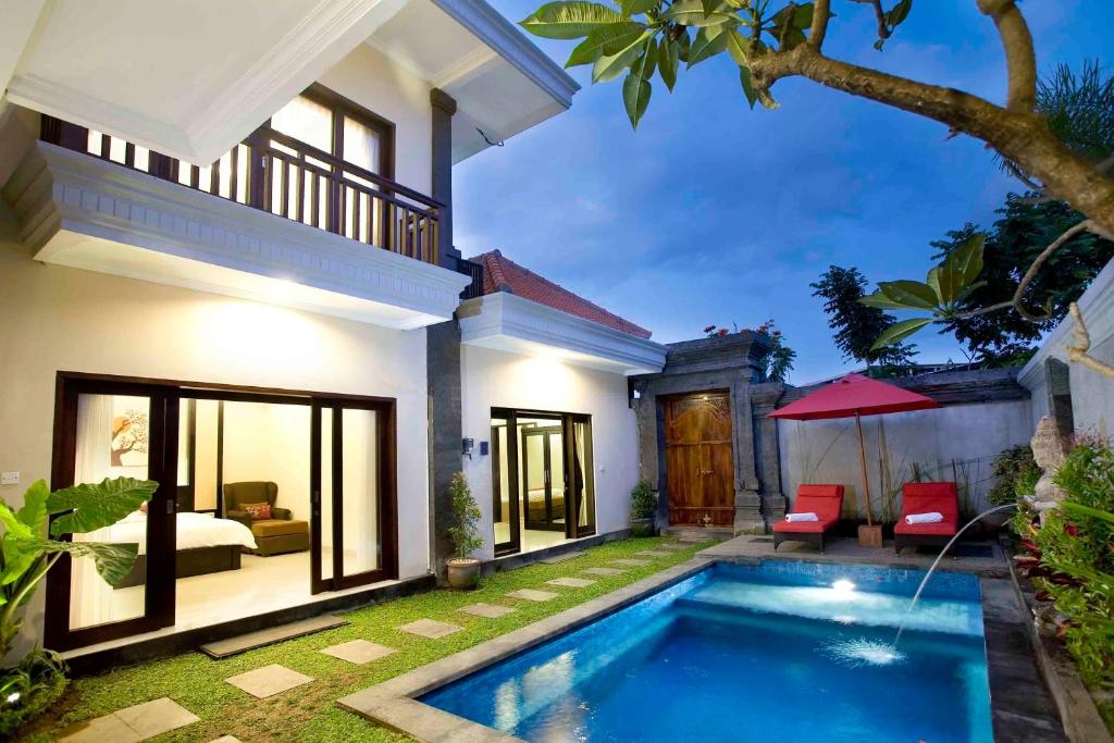 Villa con piscina frente a una casa en De' Bharata Bali Villas, en Seminyak