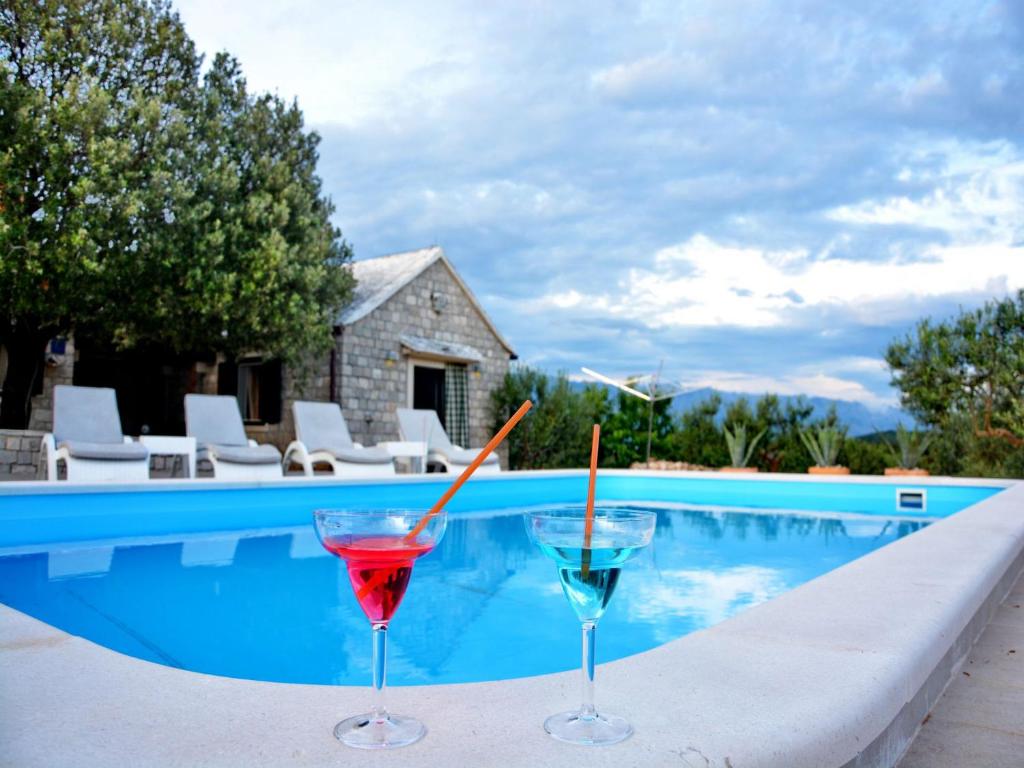 twee cocktails op een richel naast een zwembad bij Villa Tonka - with pool in Pučišća