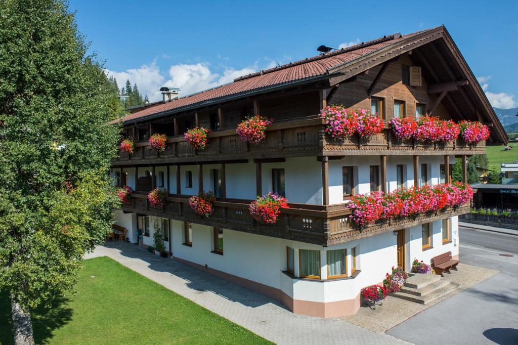 un bâtiment avec des boîtes de fleurs sur son côté dans l'établissement Gruggerhof, à Seefeld in Tirol