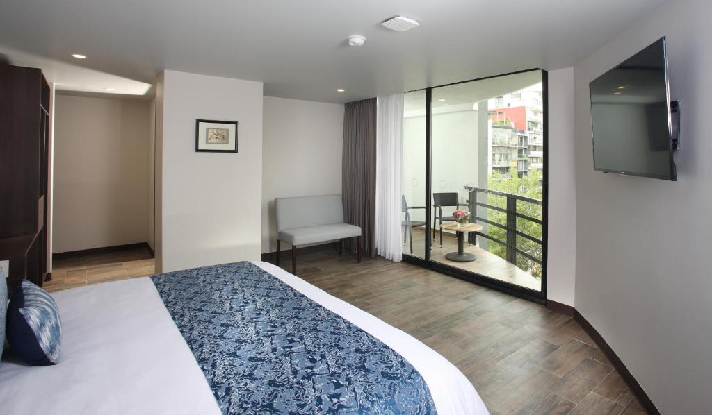 um quarto com uma cama e uma varanda com uma televisão em Hotel Círculo Condesa em Cidade do México