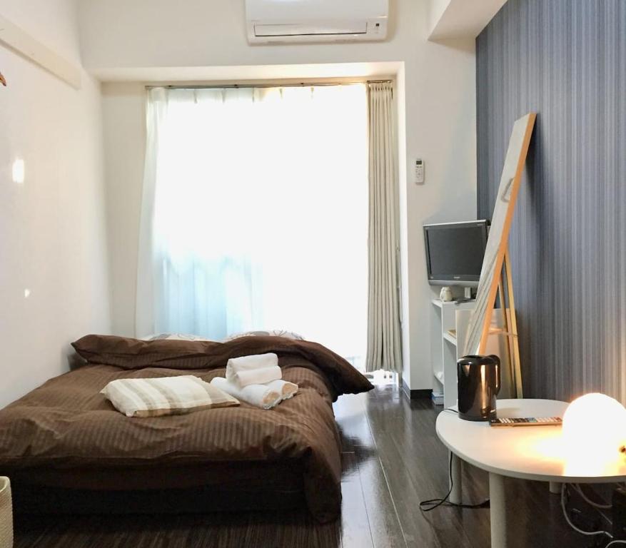 1 dormitorio con 1 cama con 2 toallas en Hirose inn F+ en Hiroshima