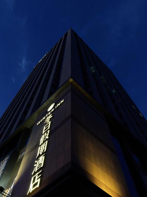 a tall building with a sign on it at night at Harbin Week Inn Hotel in Harbin