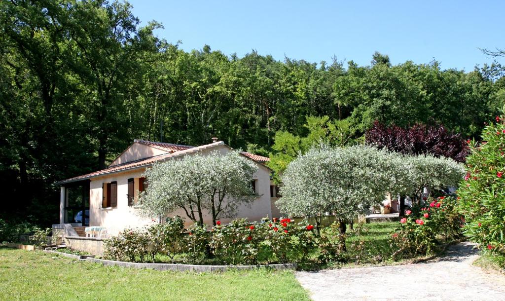 una piccola casa in un giardino con fiori e alberi di Cottage les Verveines de Vaison a Vaison-la-Romaine
