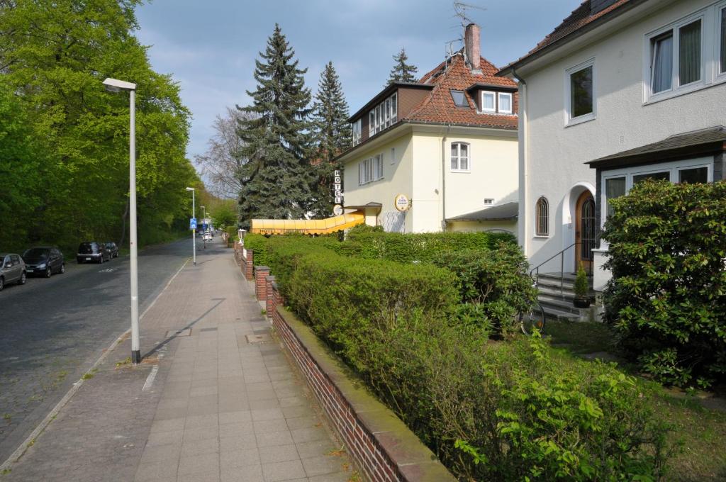 a sidewalk next to a house and a street at Hotel Hubertus in Hannover