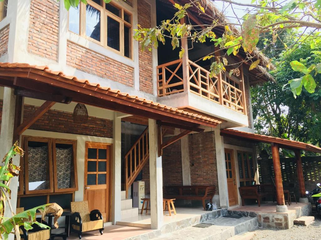 une maison avec un balcon sur le côté de celle-ci dans l'établissement Saka Homestay Boutique & Cafe, à Borobudur