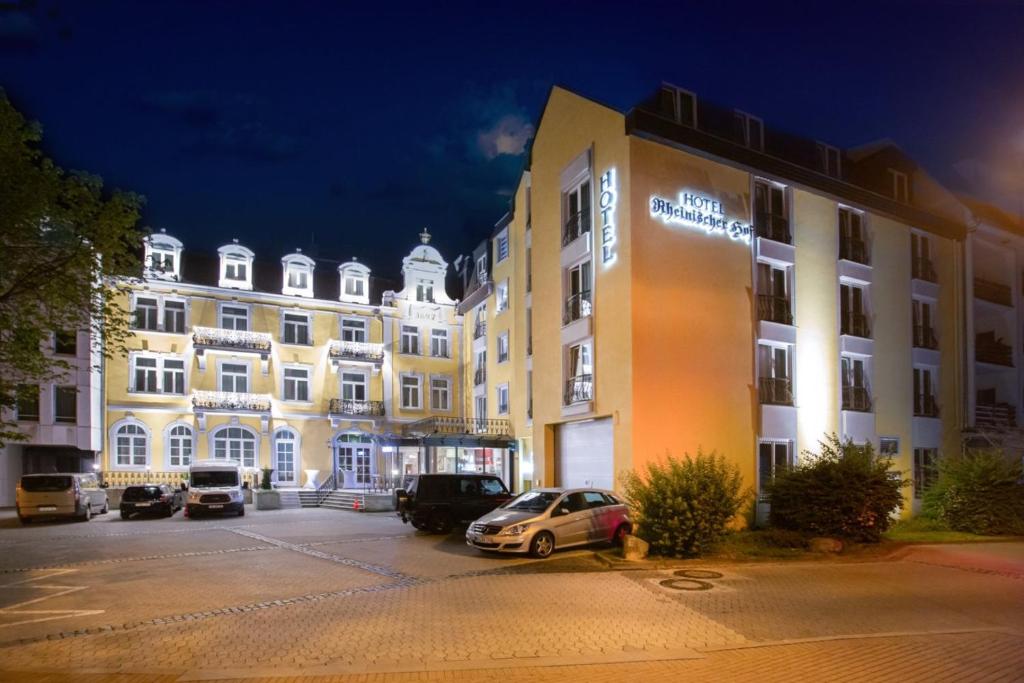 un grand bâtiment avec des voitures garées dans un parking dans l'établissement Hotel Rheinischer Hof Bad Soden, à Bad Soden am Taunus