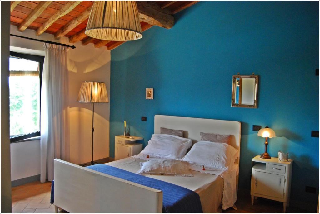 Dormitorio azul con cama y pared azul en Il Cantuccio, en Cascina