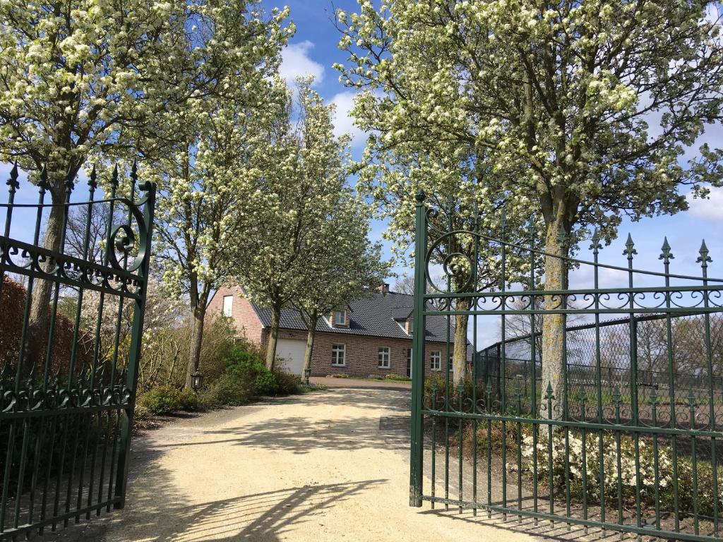 a gate in front of a house with trees at Vakantiewoning Pelterheggen in Grote Heide