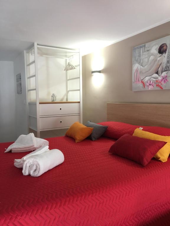 a bedroom with a large bed with red sheets and pillows at Casa Vacanza Mar' illù in Castellammare del Golfo