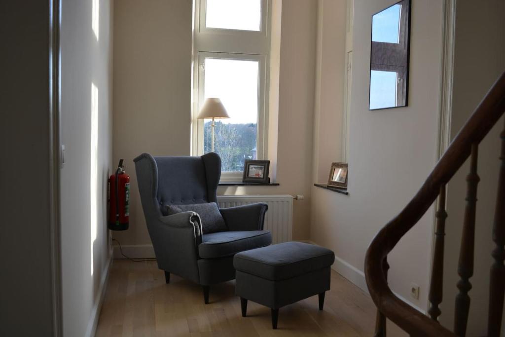 a living room with a chair and a stool at Luxe vakantiehuis Chatododo in Rochefort