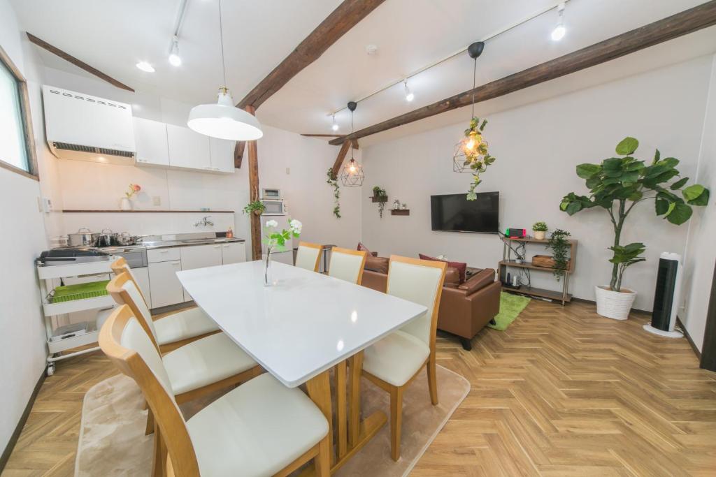 a kitchen and dining room with a white table and chairs at Nao's House USJ 一軒家貸切 in Osaka
