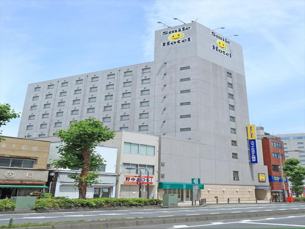 un edificio con un cartel krispy kreme en él en Smile Hotel Kumagaya, en Kumagaya