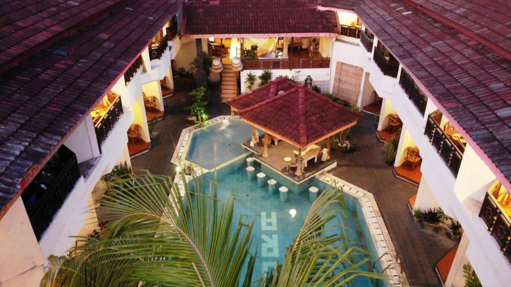 een luchtzicht op een gebouw met een zwembad bij The Flora Kuta Bali in Kuta