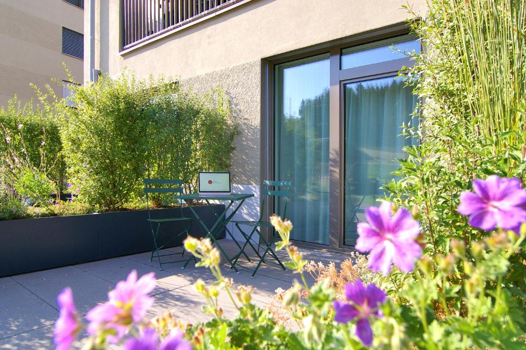 eine Terrasse mit einem Tisch und einem Laptop darauf in der Unterkunft VARIAS Lifestyle Apartments in Elsau