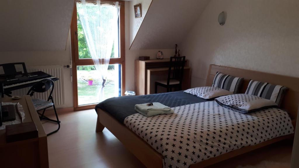 a bedroom with a bed and a desk and a window at Kerniguez 3 in Carhaix-Plouguer
