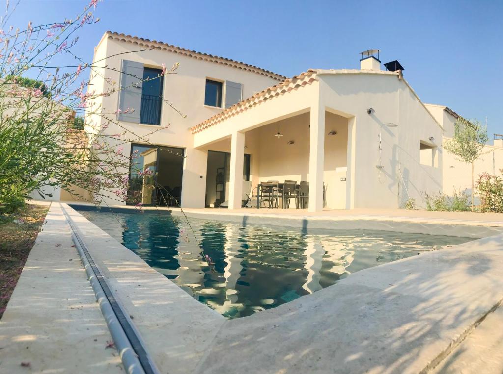 a house with a swimming pool in front of a house at Mas Partout in Malaucène