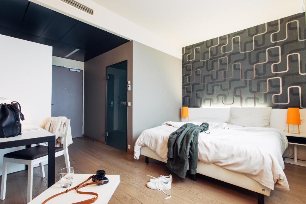 Schlafzimmer mit einem Bett, einem Tisch und einem Schreibtisch in der Unterkunft harry's home hotel & apartments in München