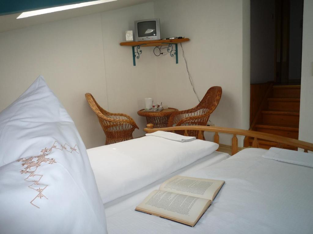 twee bedden in een kamer met een boek erop bij biozertifiziertes Hotel Höpfigheimer Hof mit Wein-Shop in Steinheim an der Murr