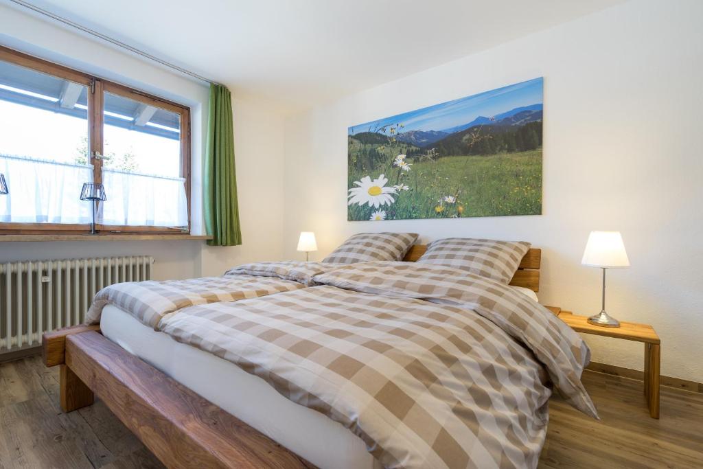 um quarto com uma cama e um quadro na parede em Ferienwohnungen Alpentraum - Landhaus Eberle em Oberstdorf