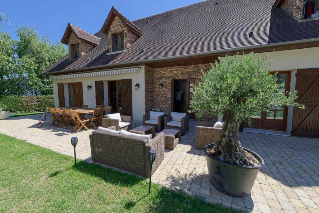 een huis met een potboom op een patio bij Le Clos Magedon in Médan