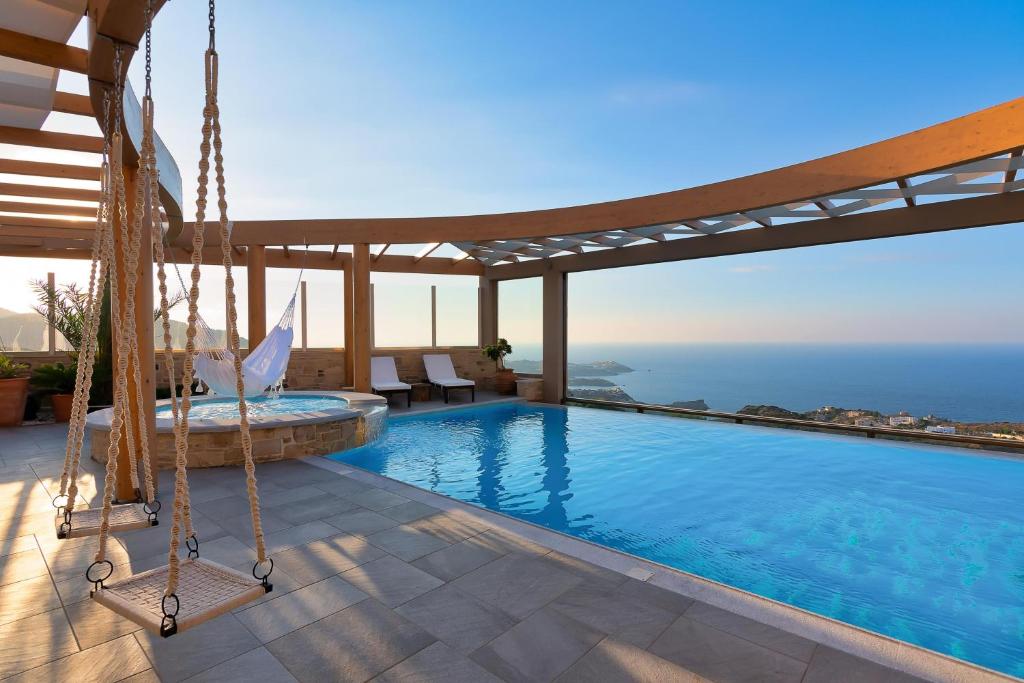 アギア・ペラギアにあるMinimalist Mediterranean Blue key Villa with Sea View Infinity Poolのスイミングプールとブランコ付きのヴィラ