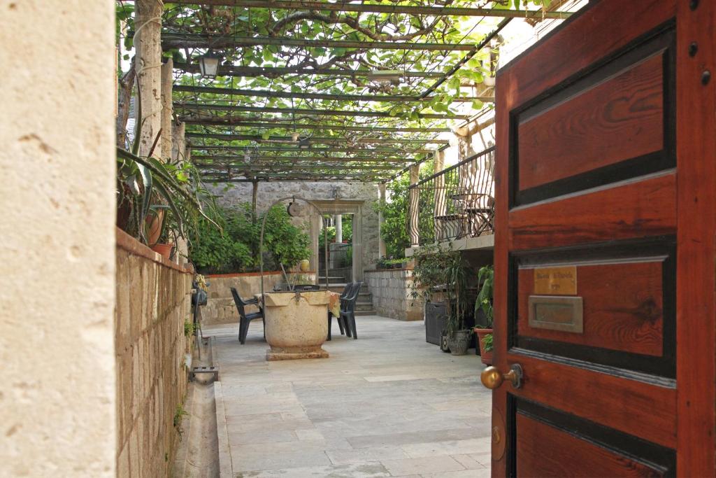 einen Innengarten mit einer Pergola und einer Tür in der Unterkunft Old Town Garden Apartments in Dubrovnik