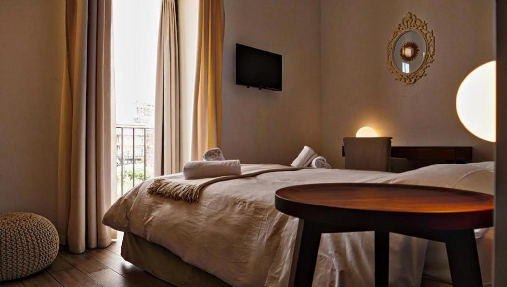 a bedroom with a bed with a table and a window at Casa Matilde in Taranto