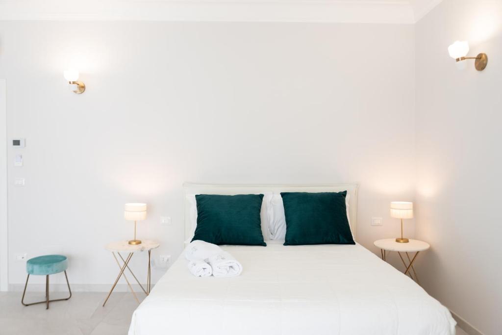 a bedroom with a white bed with green pillows at Li Cetti in Lecce