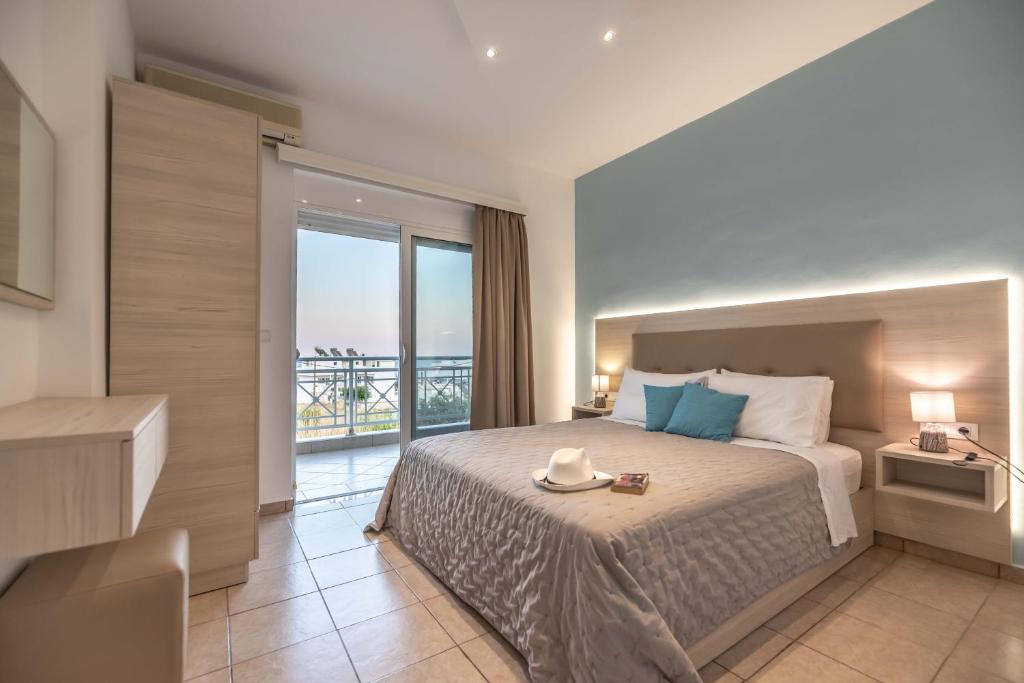 a bedroom with a large bed and a balcony at Stegna Bay Apartment in Archangelos