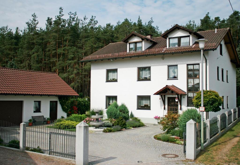 una casa blanca con valla y entrada en Ferienwohnung Maria, en Nittenau