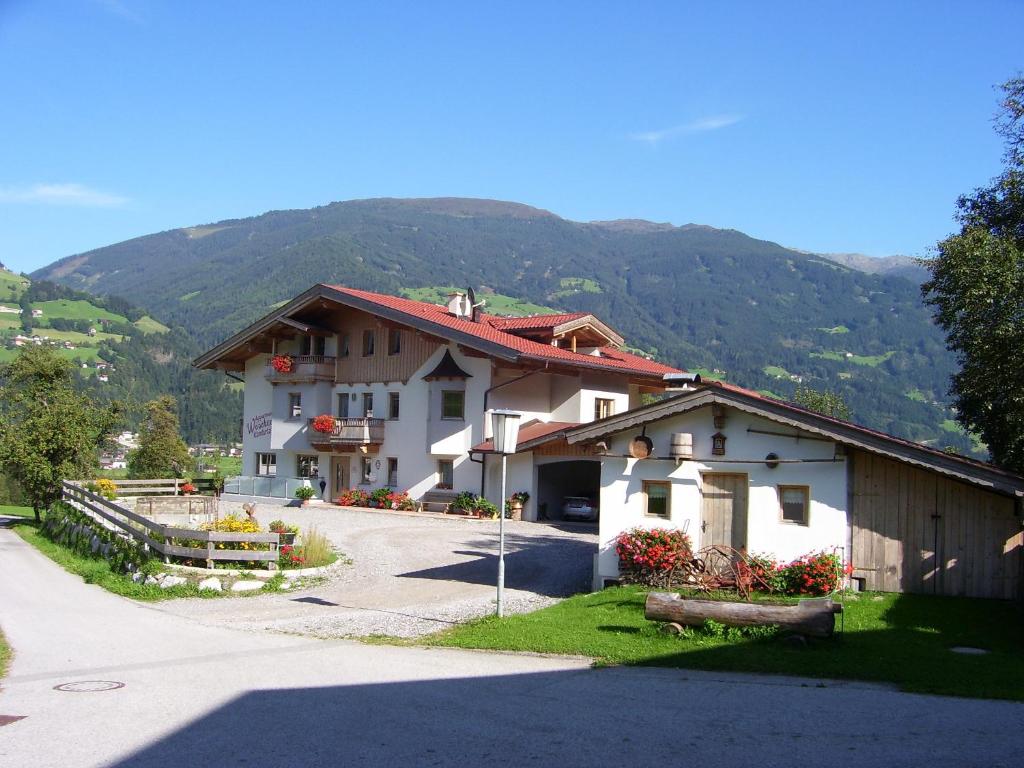 a large house with a mountain in the background at Wöscherhof in Kaltenbach