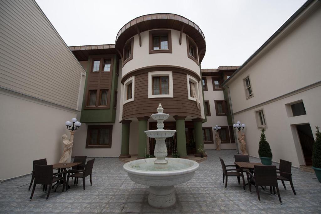 a building with a fountain in the middle of a courtyard at Cesmeli Konak Hotel Silivri in Silivri