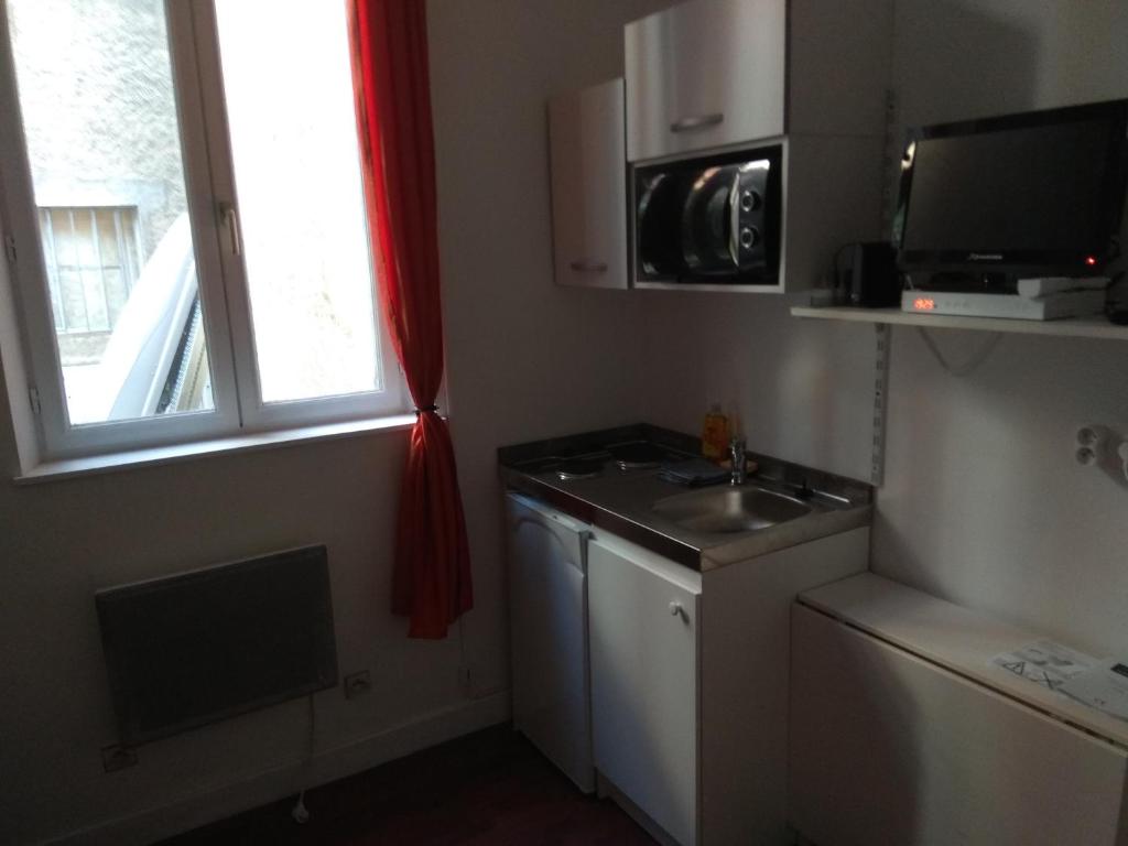 Elle comprend une petite cuisine avec un évier et une fenêtre. dans l'établissement Studio Moulins, à Moulins