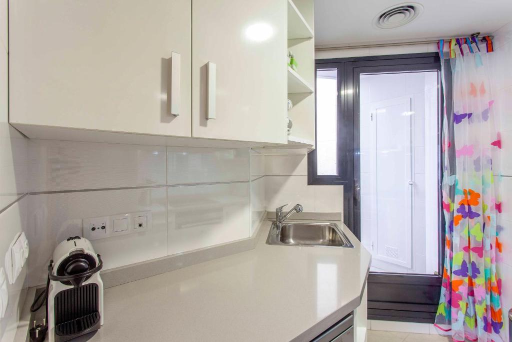 A kitchen or kitchenette at ApartUP Patacona Palm Beach I
