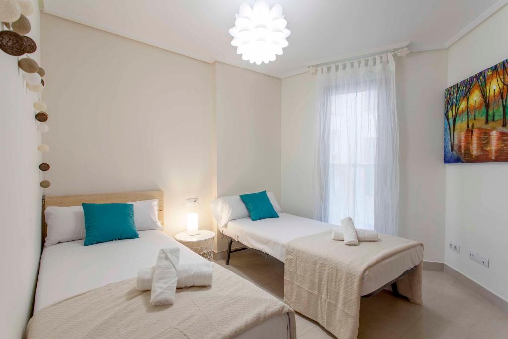 A bed or beds in a room at ApartUP Patacona Palm Beach I