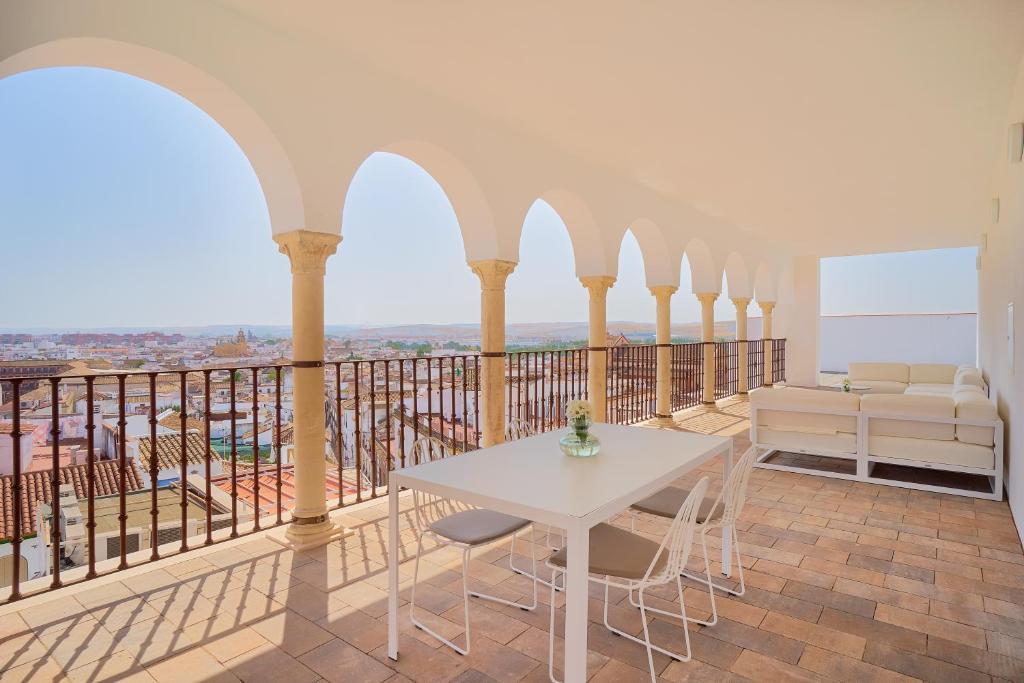 a large balcony with a white table and chairs at Tandem El Patio in Córdoba