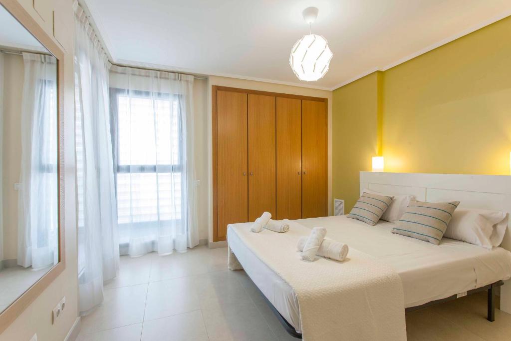 A bed or beds in a room at ApartUP Patacona Palm Beach I
