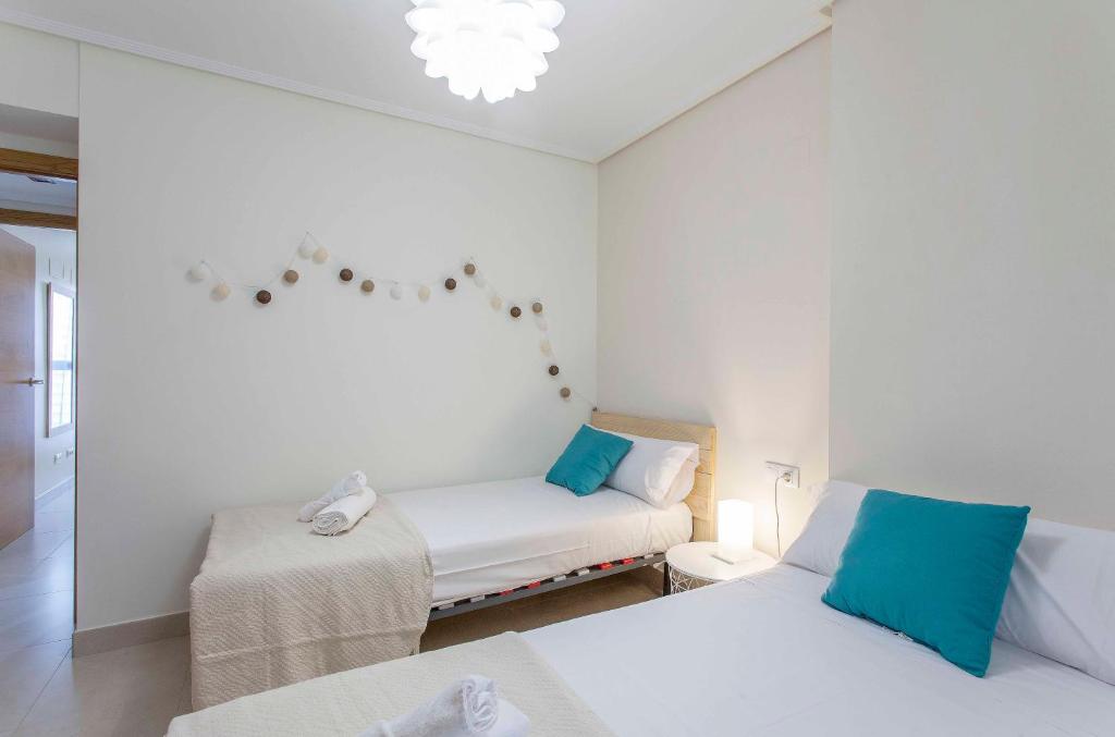 A bed or beds in a room at ApartUP Patacona Palm Beach I