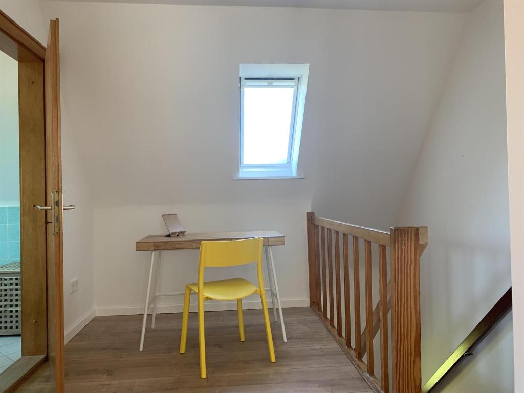 una silla amarilla sentada en una mesa en una habitación en Haus Plüschmors en Garding