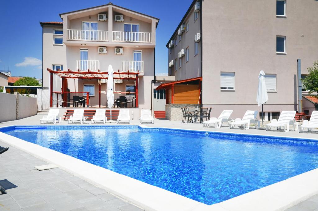 a swimming pool in front of a building at Hotel Quattro Medjugorje in Međugorje