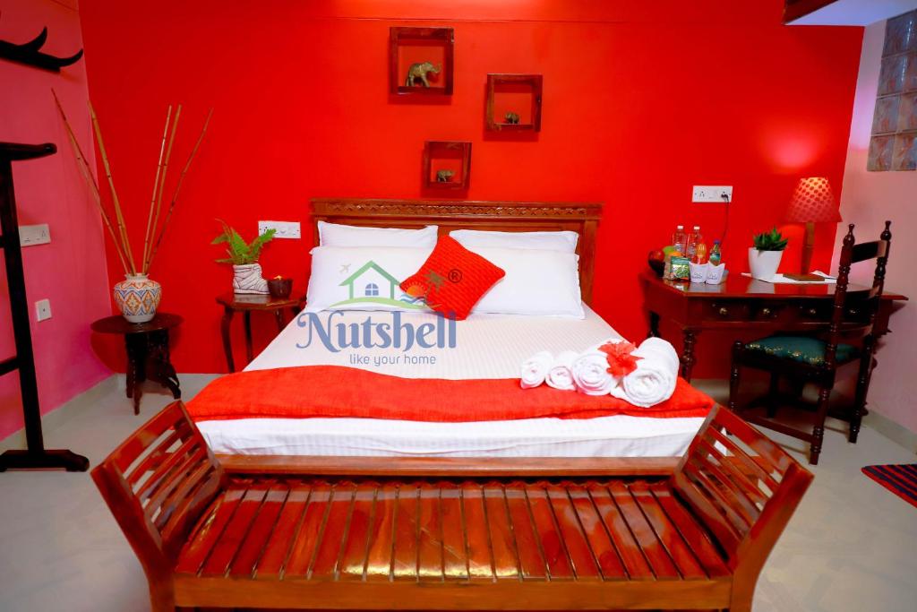 a bedroom with a bed with a red wall at Nutshell-Airport Retreat by the Sea in Trivandrum