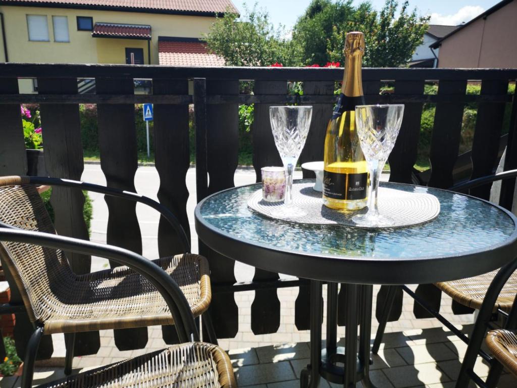 - une bouteille de vin et des verres sur une table sur une terrasse dans l'établissement Odisey, à Postojna