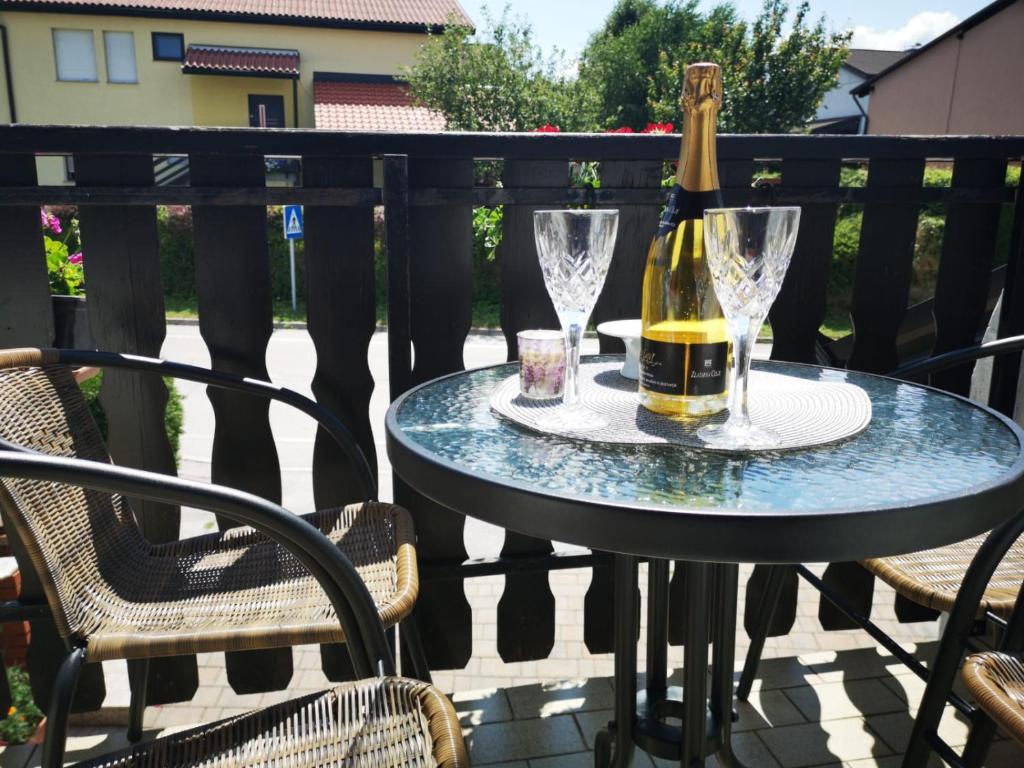 a bottle of wine and glasses on a table on a patio at Odisey in Postojna
