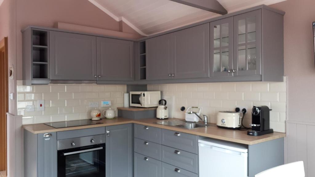 a kitchen with gray cabinets and a counter top at Suzies Self Catering Belmont in Belmont