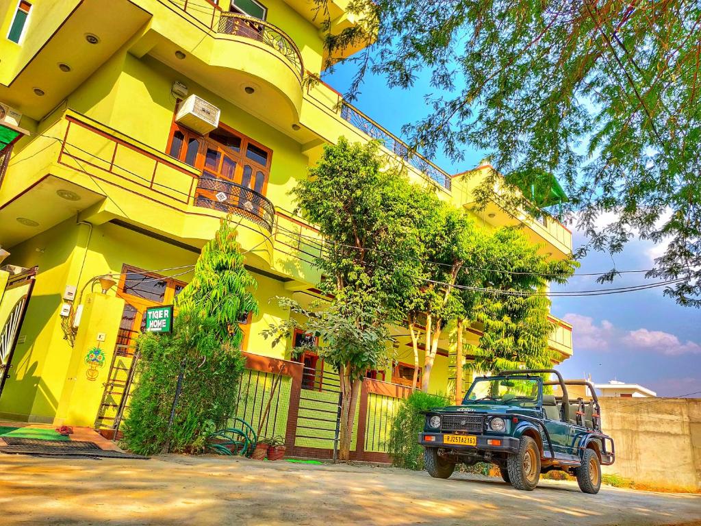 um jipe estacionado em frente a um edifício amarelo em Ranthambore Tiger Home em Sawai Madhopur