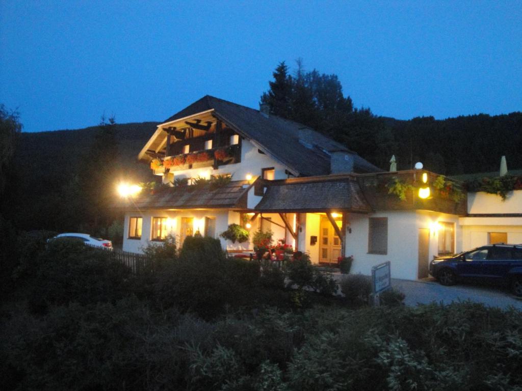 Una casa de noche con las luces encendidas en Hotel Pension Schwaiger en Sankt Margarethen im Lungau